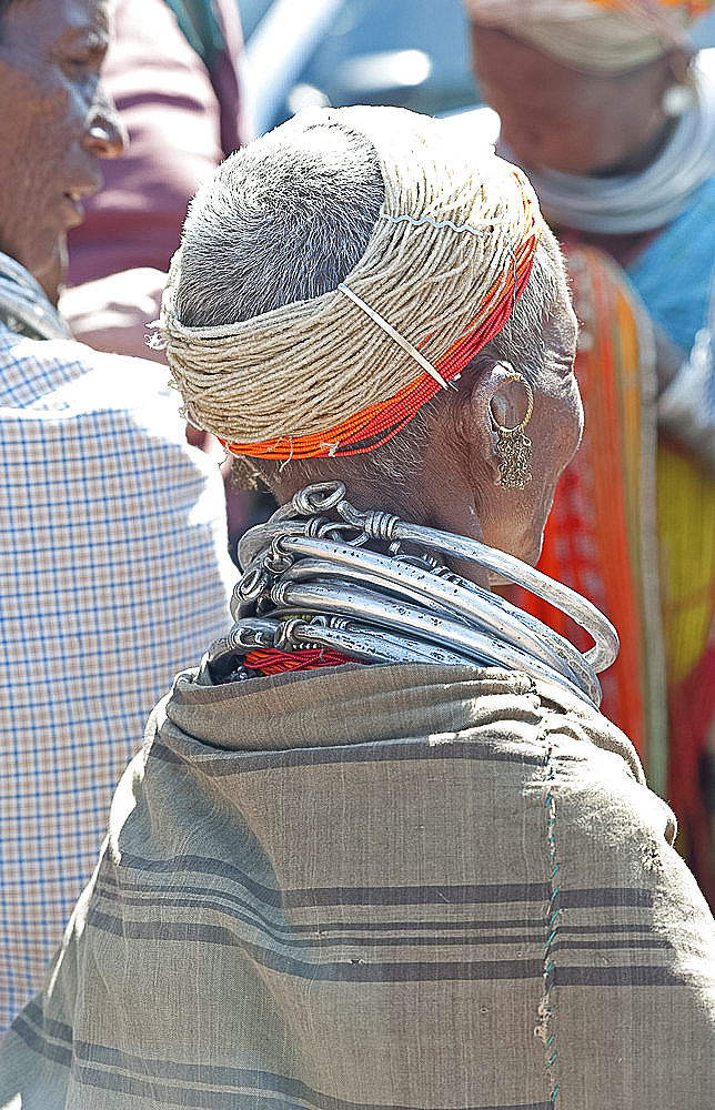 Bonda tribeswoman wearing shawl over traditional bead costume, with beaded cap and metal necklaces at weekly market, Rayagader, Orissa, India, Asia