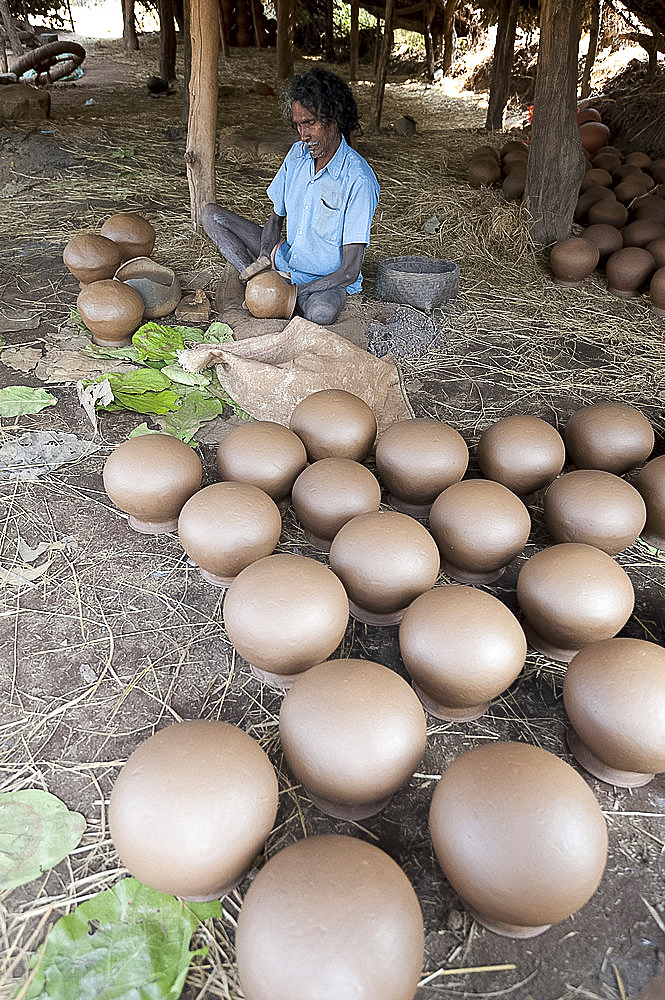 Potter making clay water pots in a thatched shelter in a rural village, near Rayagada, Orissa, India, Asia