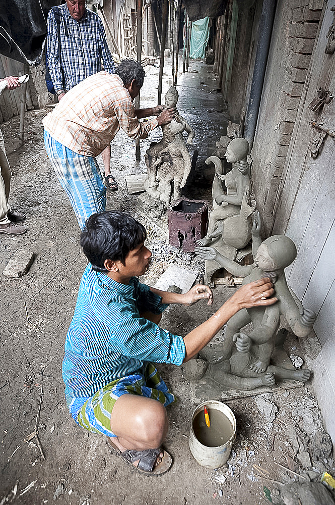 Master sculptors making models from clay from the River Hugli, to be painted for puja ceremonies, Kumartuli district, Kolkata, West Bengal, India, Asia