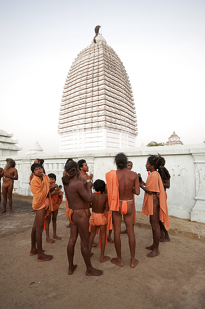 Joranda monks gathered in front of temple, vimula visible above them, after prayers at dusk, Joranda, Dhenkanal, Orissa, India, Asia