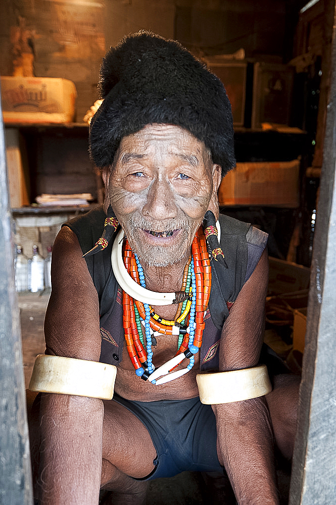 Naga Konyak tribal headhunter with traditional tattooed face, deer horn earrings, animal teeth and beads and elephant tusk armbands, Ngangting, Nagaland, India, Asia