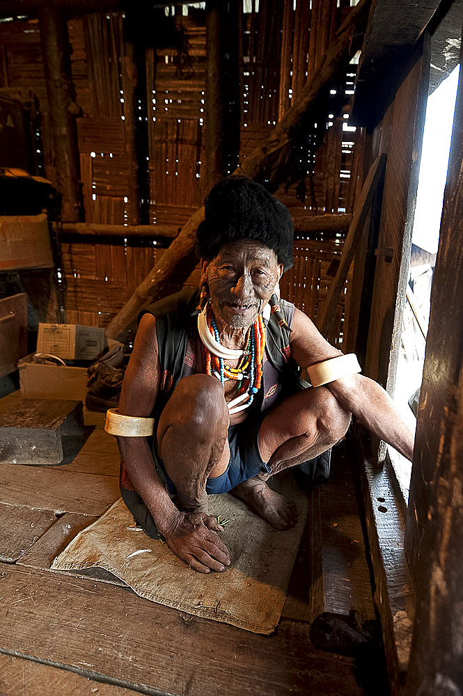 Naga Konyak tribal headhunter with traditional tattooed face, deer horn earrings, animal teeth and beads, elephant tusk armbands, Ngangting, Nagaland, India, Asia