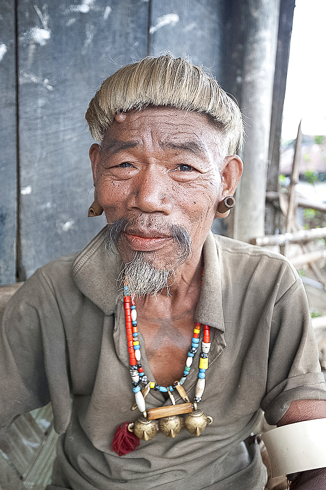 Naga Konyak tribal head hunter with traditional headhunter necklace with brass heads, bamboo earrings, elephant tusk armbands, Ngangting, Nagaland, India, Asia