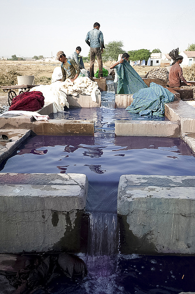 Men washing the starch or dye out of cotton cloth in running water, before drying ready for indigo dyeing, Bhuj district, Gujarat, India, Asia