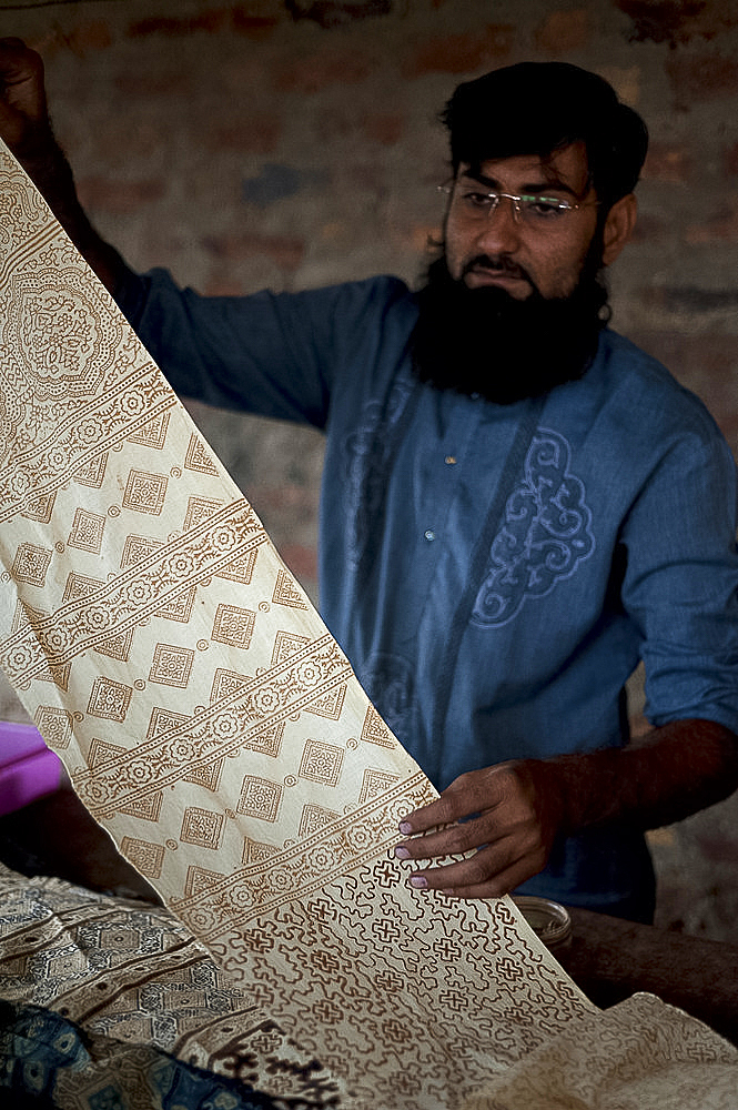 Muslim man showing hand block printed fabric using natural dye made from plants and roots, Bhuj district, Gujarat, India, Asia