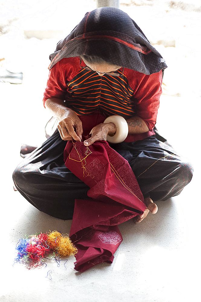 Aahir tribeswoman embroidering intricate traditional patterns in very fine chain stitch, Bhuj district, Gujarat, India, Asia