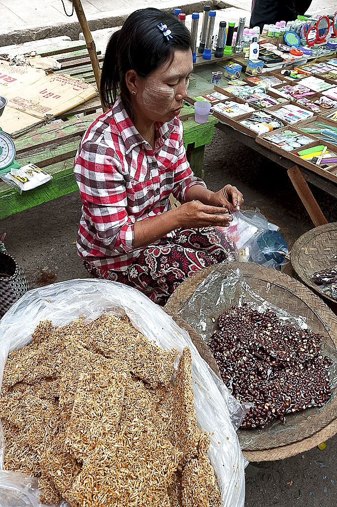 Woman selling delicious home made fresh peanut brittle and vermicelli brittle in Kalaw market, Shan state, Myanmar (Burma), Asia