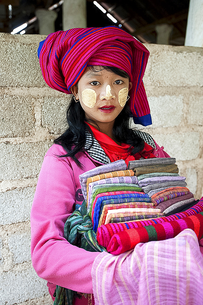 Young girl with thanaka paste on her face, selling scarves and sarongs at Nyaung Oak Monastery, Indein, Inle Lake, Shan state, Myanmar (Burma), Asia