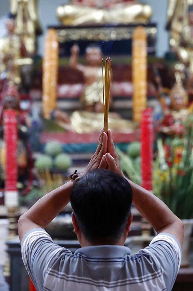 Man praying to the Buddha holding incense sticks, Tay An temple, Chau Doc, Vietnam, Indochina, Southeast Asia, Asia