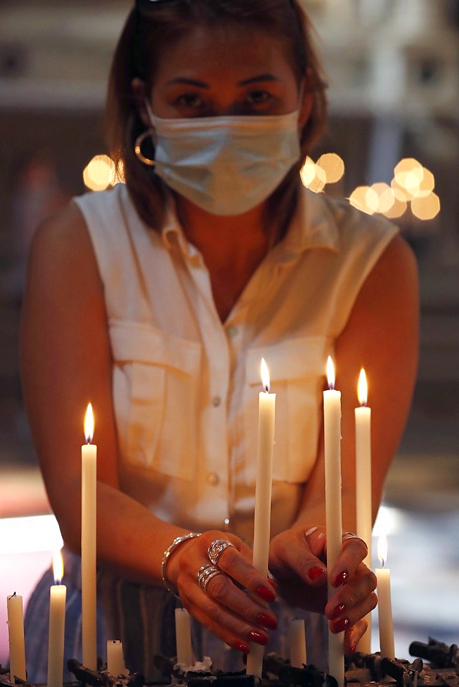 Woman with face mask praying in church during coronavirus epidemic, Venice, Veneto, Italy, Europe