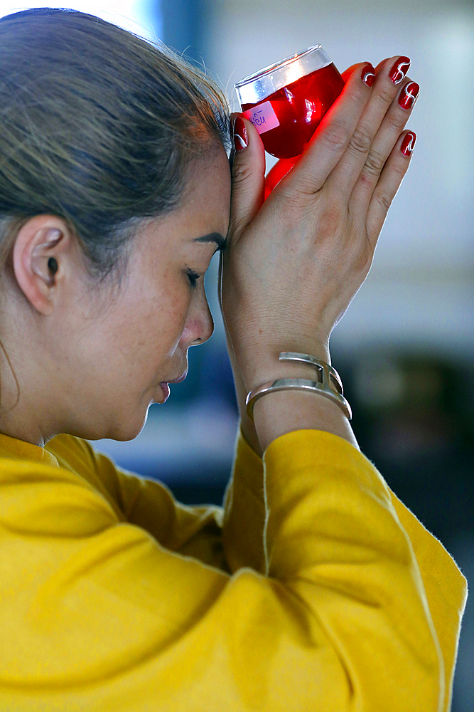 Huynh Dao Buddhist temple, woman at Buddhist ceremony praying with a candle, Chau Doc, Vietnam, Indochina, Southeast Asia, Asia