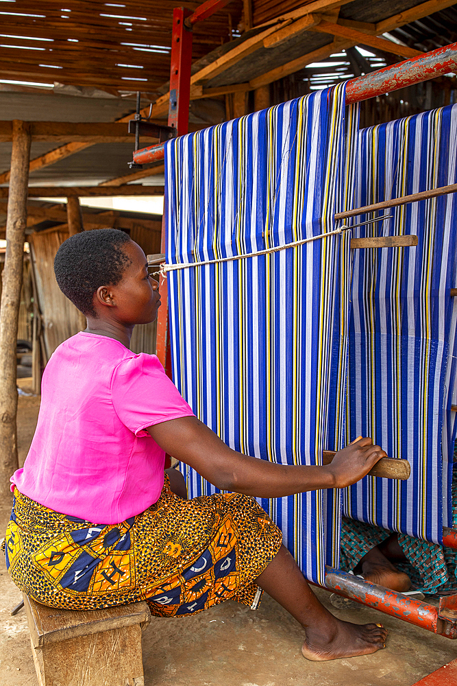 Young woman weaving on a handloom in Amlame, Togo, West Africa, Africa