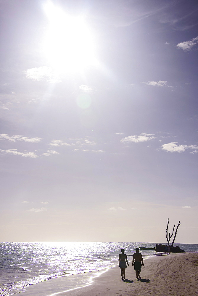 Backlit tourists walking on the beach of Bavaro, Punta Cana, Dominican Republic, West Indies, Caribbean, Central America *** Local Caption *** curves to produce overall warmer/reddish cast, removed clutter from water and other people/rubbish on the beach