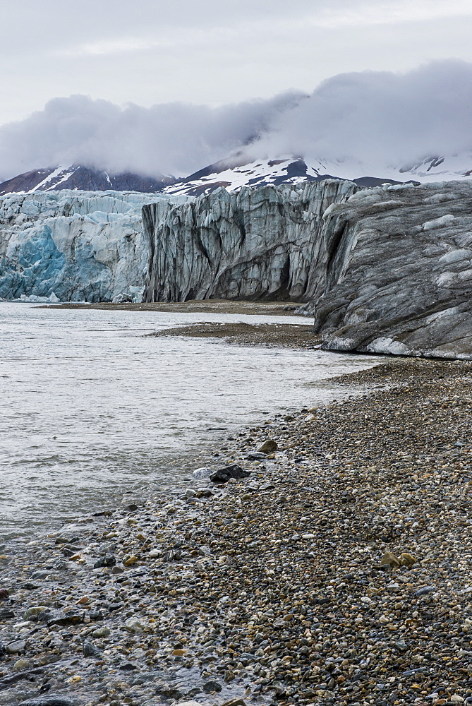 Gravel beach before a huge glacier in Hornsund, Svalbard, Arctic