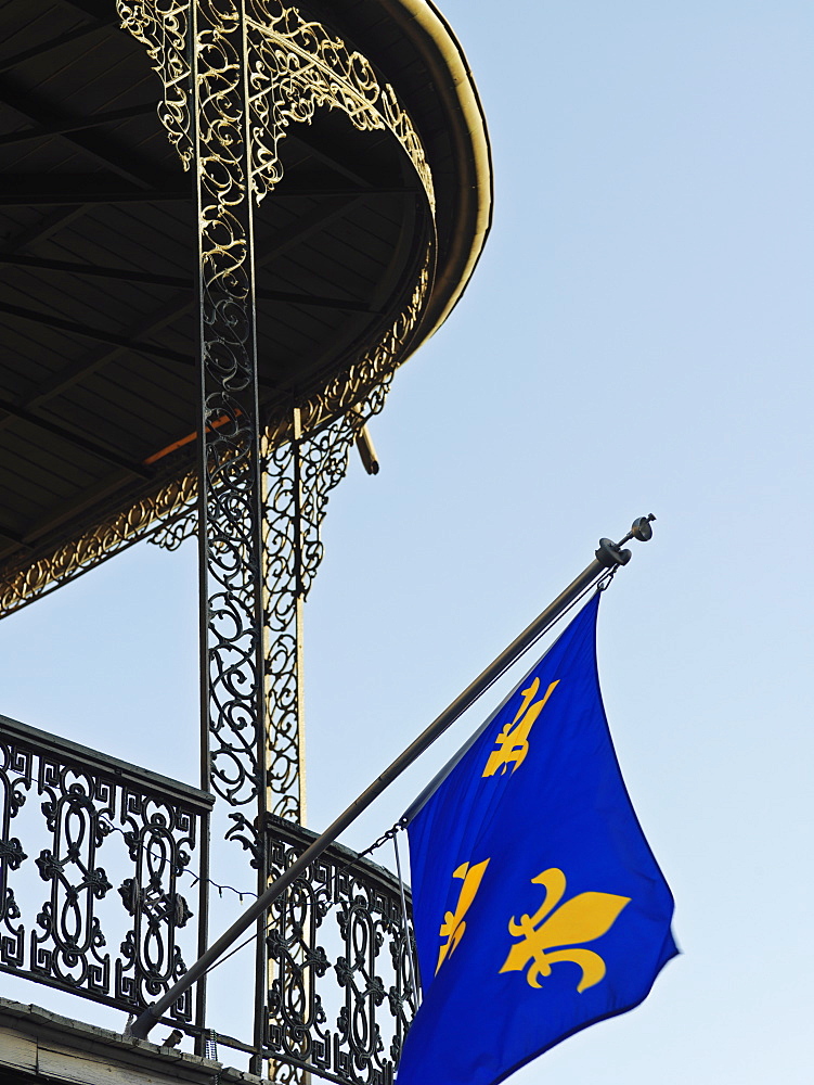 French Quarter building with wrought iron balconies and fleurs de lys flags, New Orleans, Louisiana, United States of America, North America