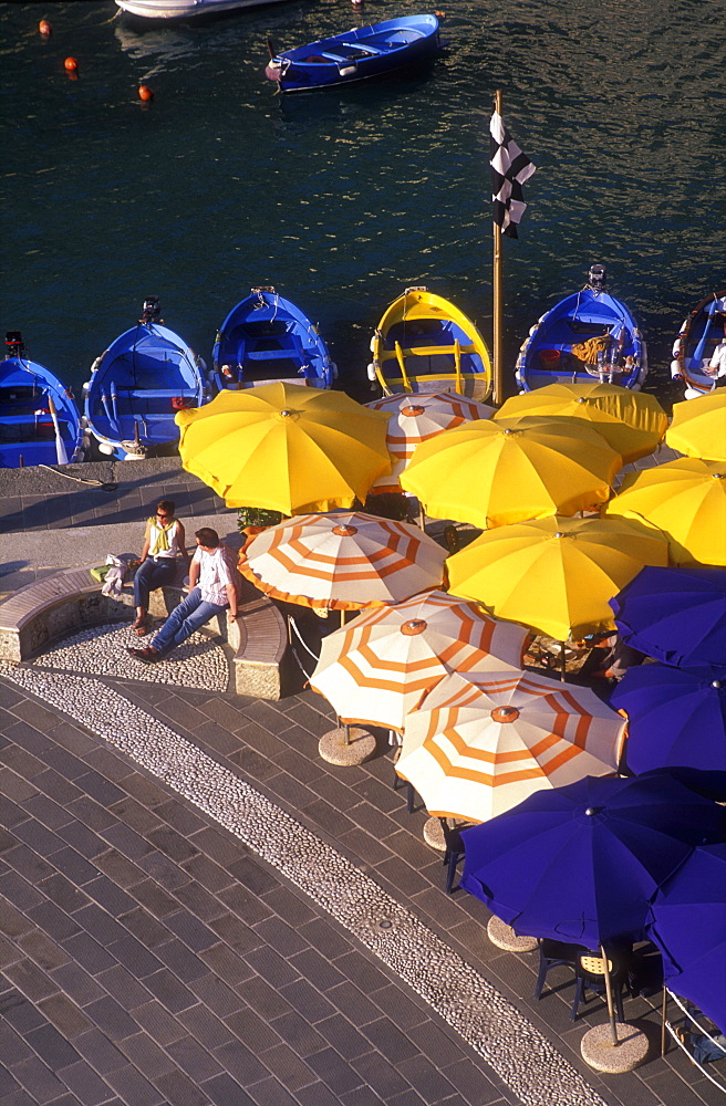 Colorful umbrellas, fishing boats and a couple seated, Vernazza, Cinque Terre, Liguria, Italy, Europe