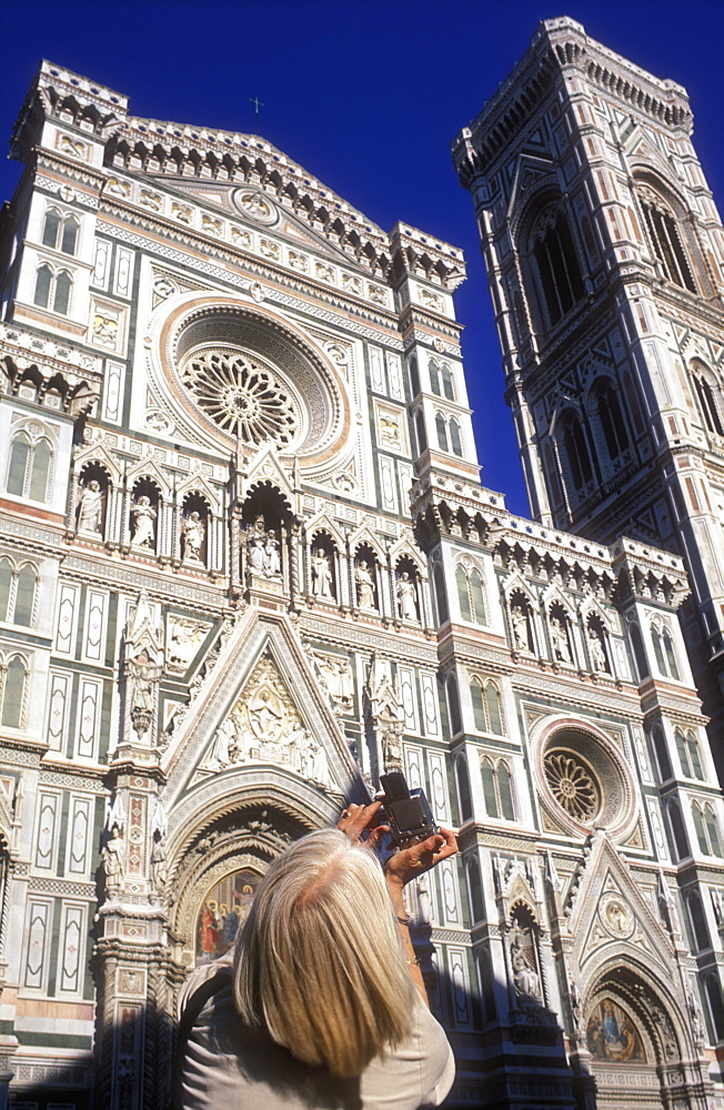 Woman taking a photo of the Cathedral of Santa Maria del Fiore (The Duomo), Piazza del Duomo, Florence, Tuscany, Italy, Europe