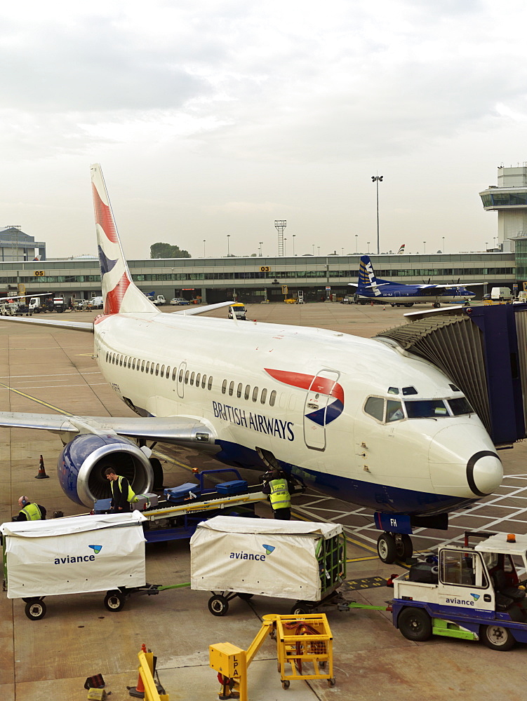 British Airway plane at terminal with baggage being unloaded, Heathrow Airport, London, England, United Kingdom, Europe