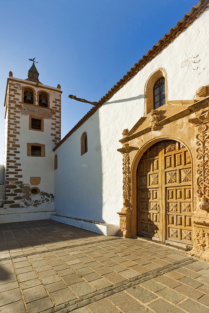 Door and belltower of the 17th century Santa Maria Cathedral in this historic former capital, Betancuria, Fuerteventura, Canary Islands, Spain, Europe