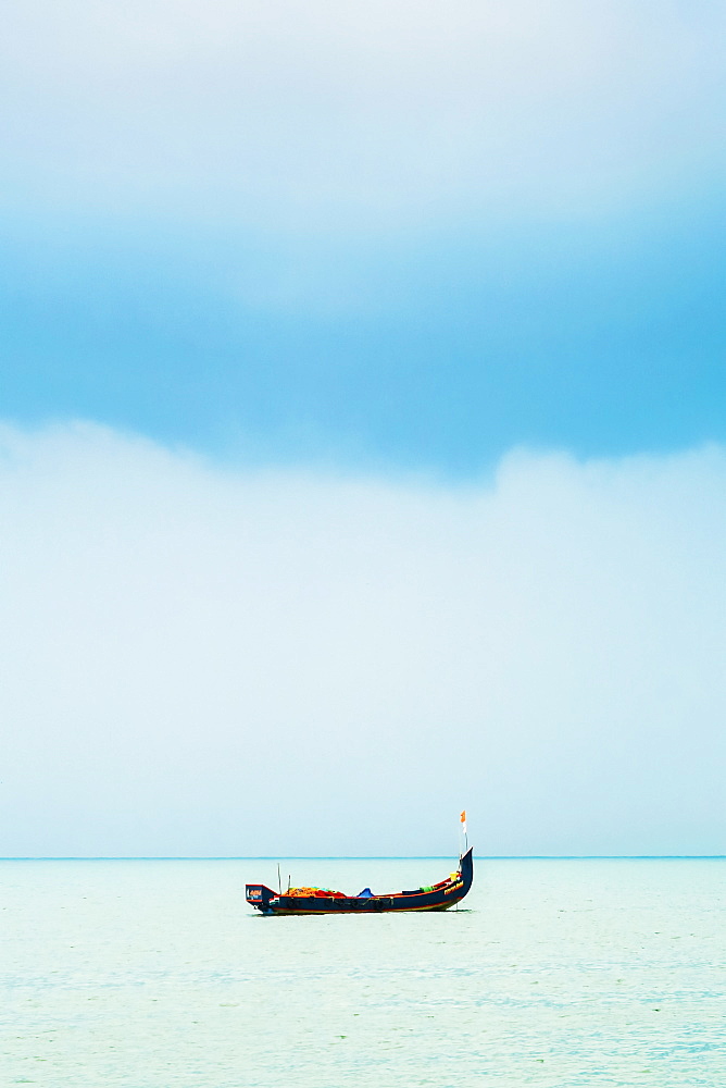 Fishing boat on Arabian Ocean with Monsoon clouds, off popular Marari Beach, Mararikulam, Alappuzha (Alleppey), Kerala, India, Asia