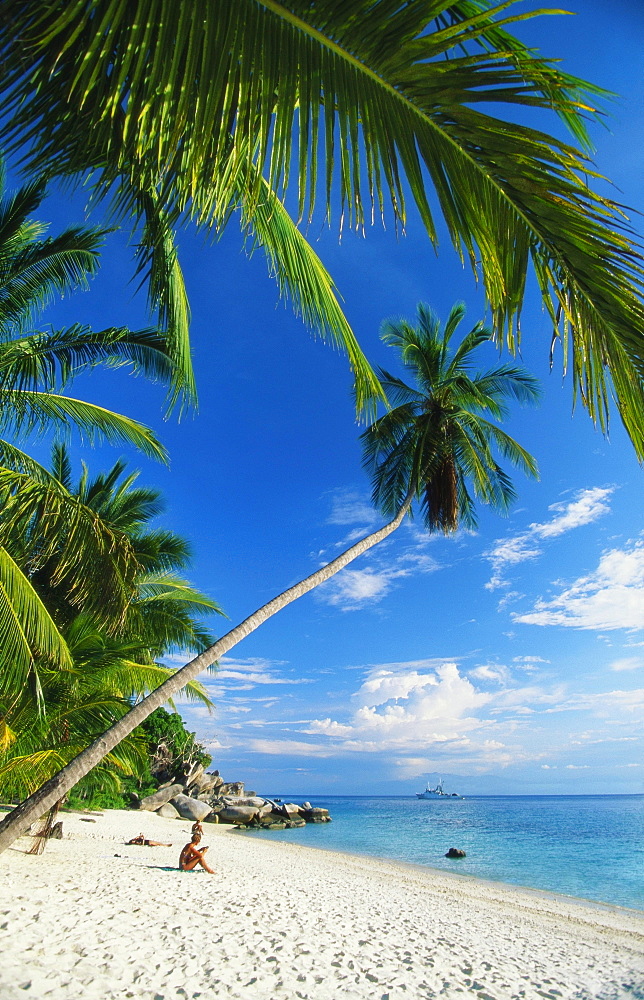 Three People Sunbathing on the Beach of Terengganu, Perhentian Besar, Malaysia