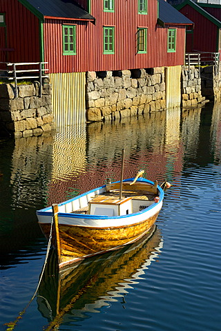 Colourful Rorbuer houses at the shore with boat Stamsund Vestvagoya Lofoten Norway