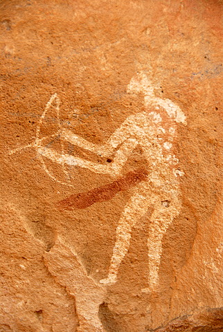 Neolithic rock drawing of a hunting man with weapons bow and arrow Acacus Libya