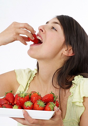Young woman eats strawberries