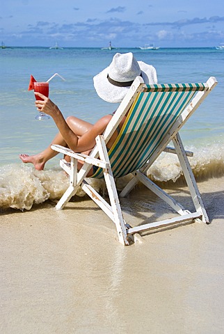 Woman with cocktail enjoys holidays at sea