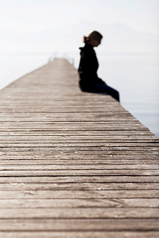 Woman sitting on a wooden jetty, Chiemsee Lake, Bavaria, Germany, Europe, PublicGround