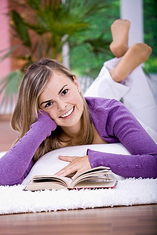 Young woman reading on the sofa in the living room