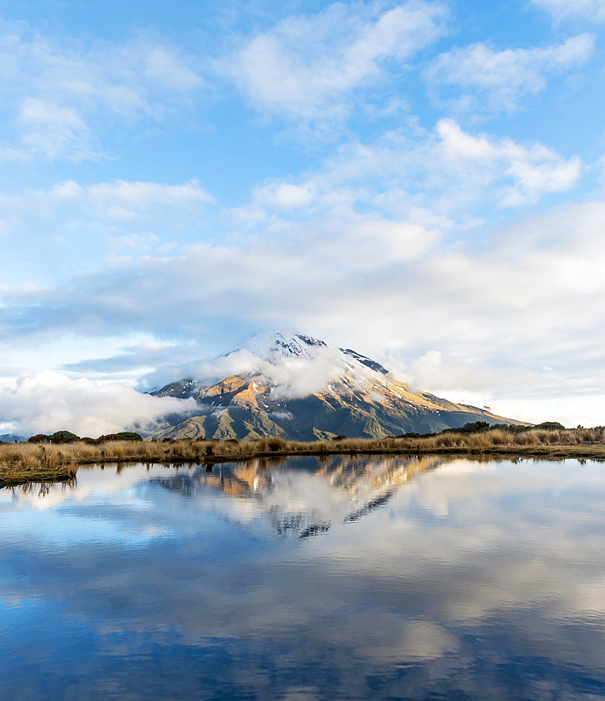 Reflection in Pouakai Tarn, stratovolcano Mount Taranaki or Mount Egmont with cloud, Egmont National Park, Taranaki, New Zealand, Oceania