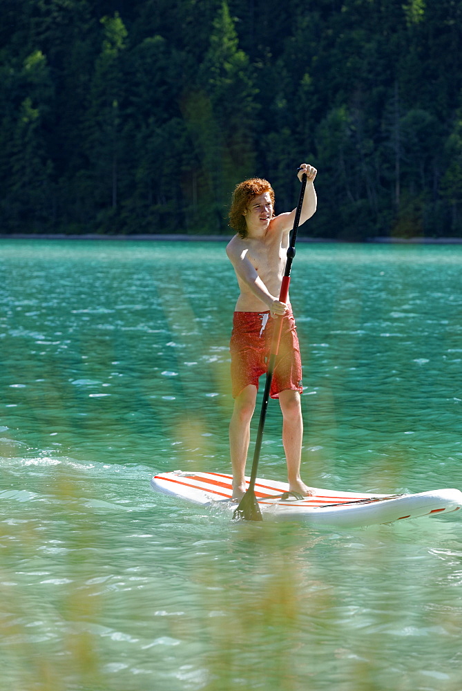 Teenager, Paddleboarding, Lake Plansee, Ammergau Alps, Tyrol, Austria, Europe