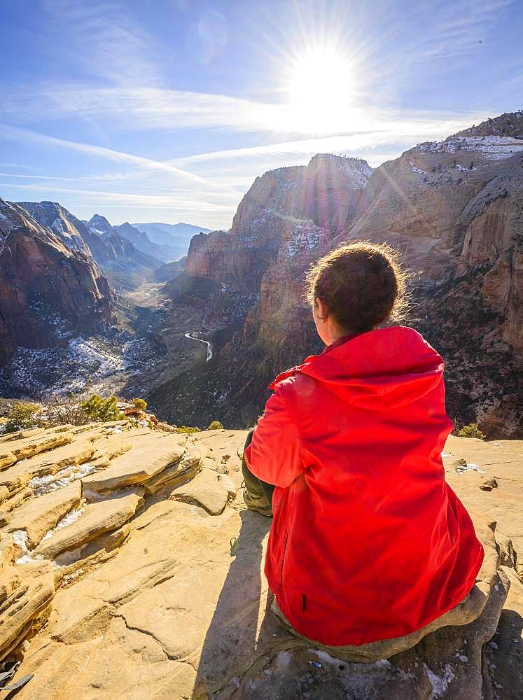 Young woman looking into the distance from Angels Landing to Zion Canyon, Angels Landing Trail, in winter, mountain landscape, Zion National Park, Utah, USA, North America