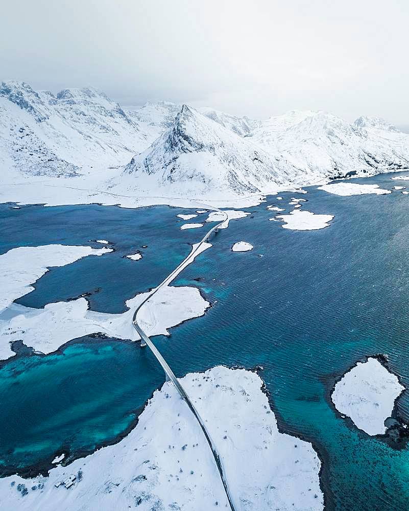 Snow-covered landscape at the fjord with Fredvang bridges, drone shot, Lofoten, Norway, Europe