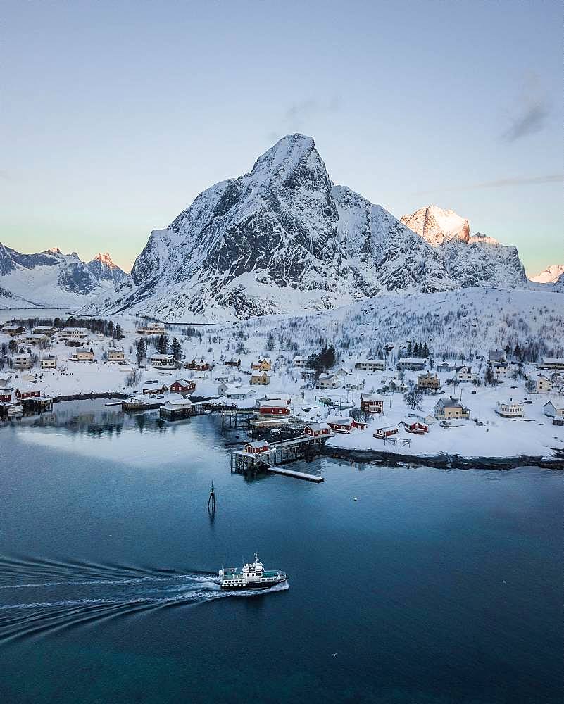 Place Reine voe snowy mountains with passenger boat, drone shot, Lofoten, Norway, Europe