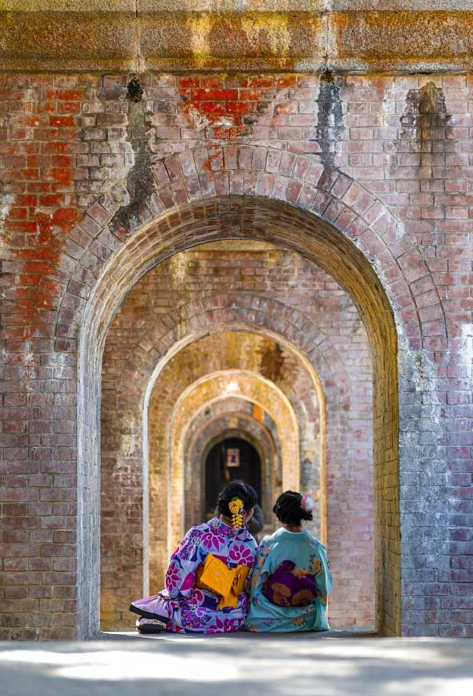 Two Japanese women in kimono sitting at the Suirokaku aqueduct, Kyoto, Japan, Asia