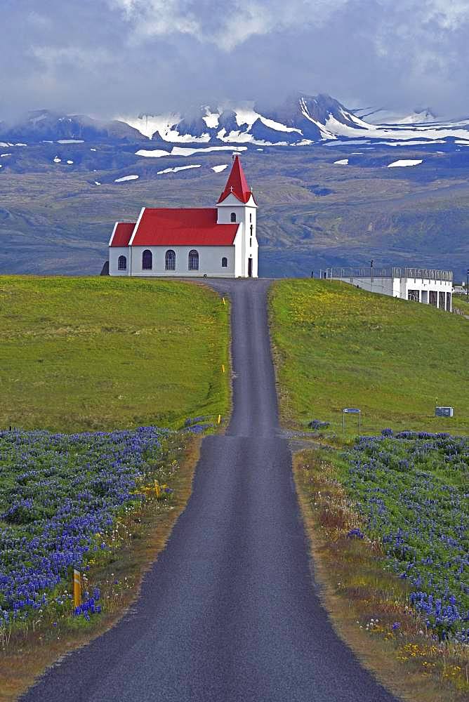 Road leads to the church of Ingjaldsholl behind the Snaefellsnessjoekull, Snaefellsness Peninsula, Iceland, Europe