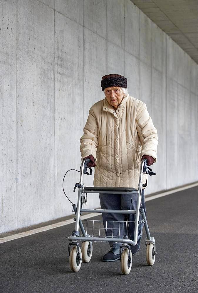 Senior citizen with walker walks in an underpass, Austria, Europe