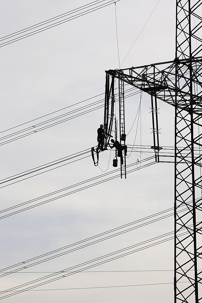 High voltage engineers working on high voltage pylons, Baden-Wuerttemberg, Germany, Europe