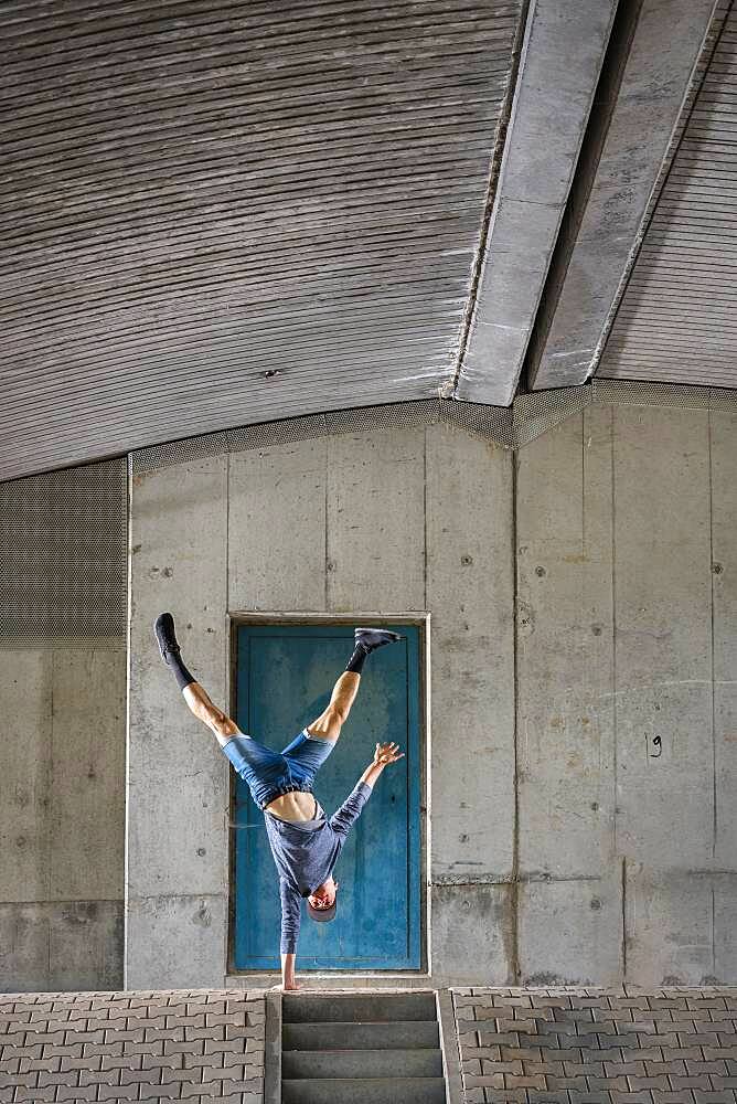 Teenager, 19 years, in handstand, under bridge, Germany, Europe