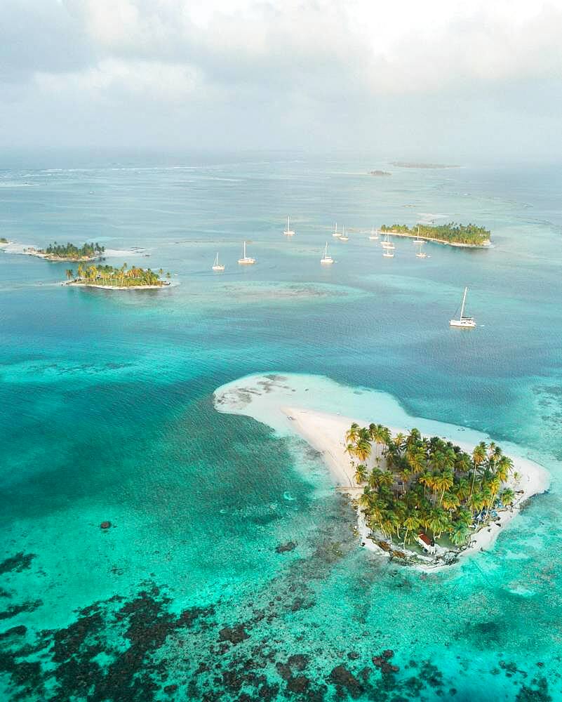 Aerial view, sailing boats between several small tropical palm islands, San Blas Islands