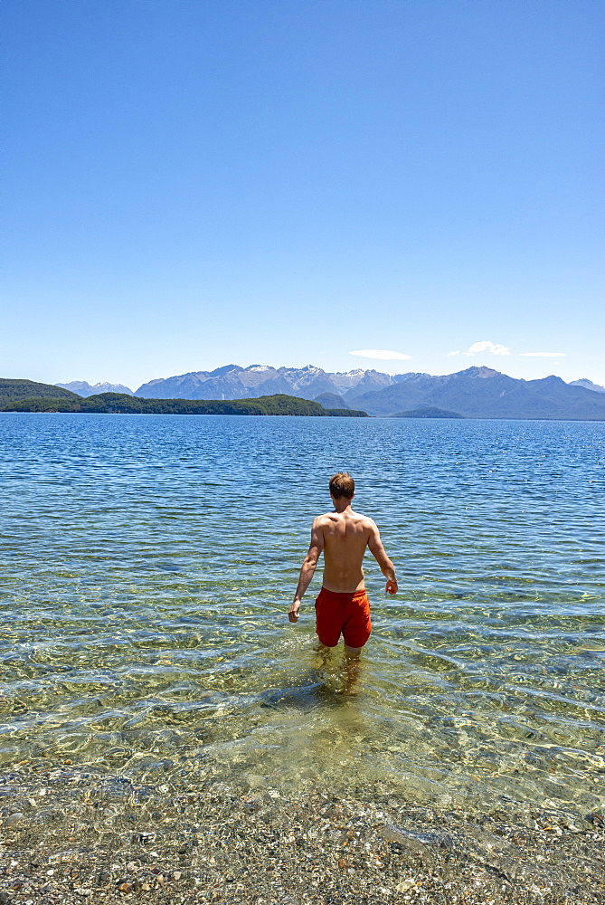 Young man bathes in the lake, Lake Manapouri, Frasers Beach, Manapouri, South Island, New Zealand, Oceania