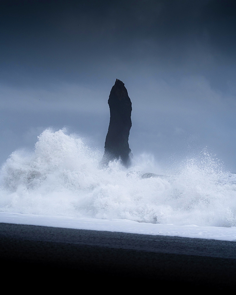 Sharp rock with strongly breaking waves on a volcanic beach, Vik, Iceland, Europe