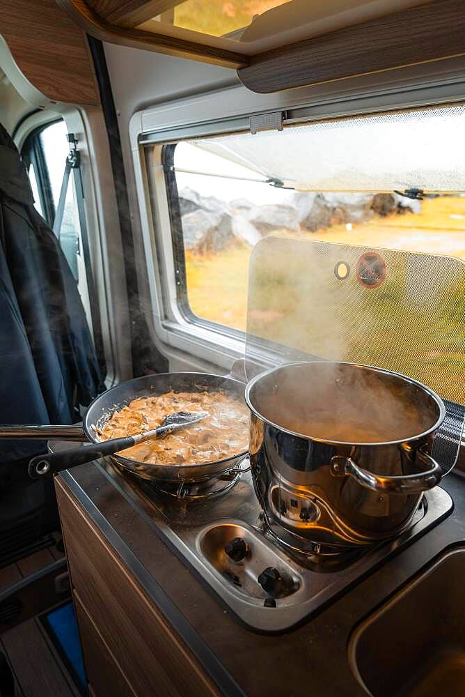 Spaghetti with creamy cream sauce cooked on gas stove in Campervan, Moskenes Camping, Lofoten, Norway, Europe