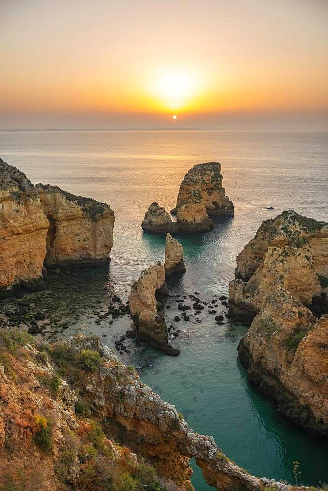 Rugged rocky coast with cliffs of sandstone, rock formations in the sea, Ponta da Piedade, dawn at sunrise, Algarve, Lagos, Portugal, Europe