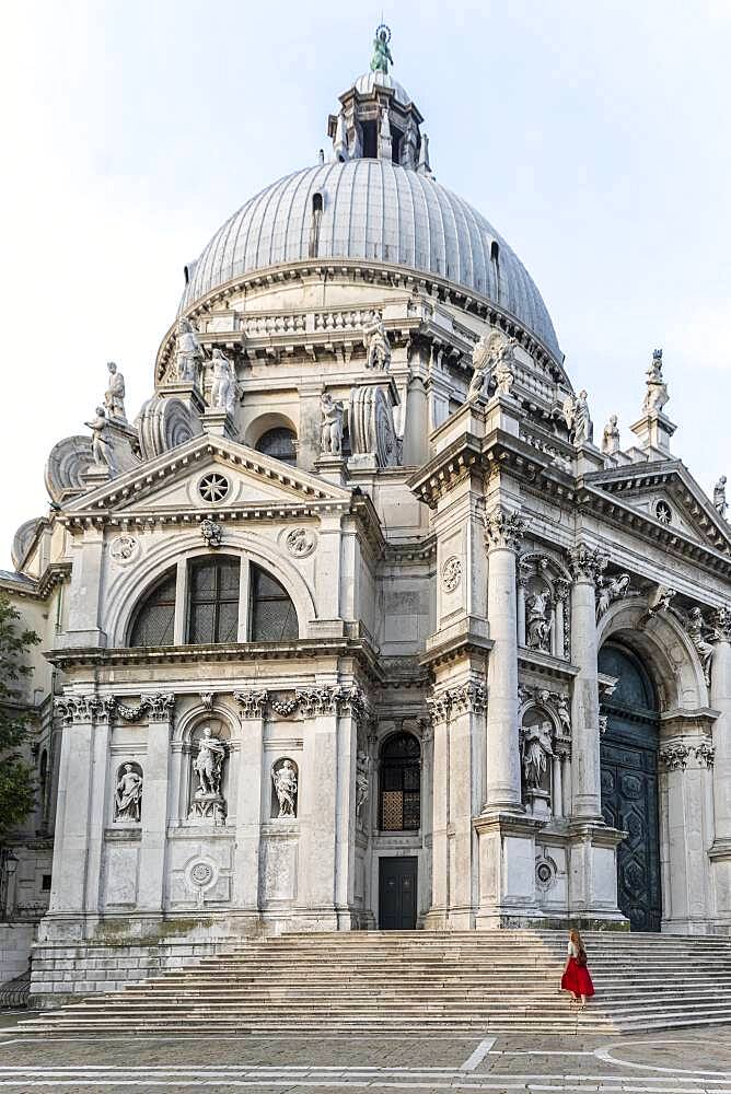 Young woman with in front of church, Basilica di Santa Maria della Salute, Venice, Veneto, Italy, Europe