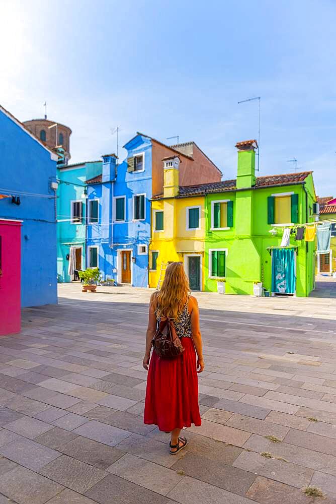 Young woman in front of colorful houses, colorful house facades, Burano Island, Venice, Veneto, Italy, Europe