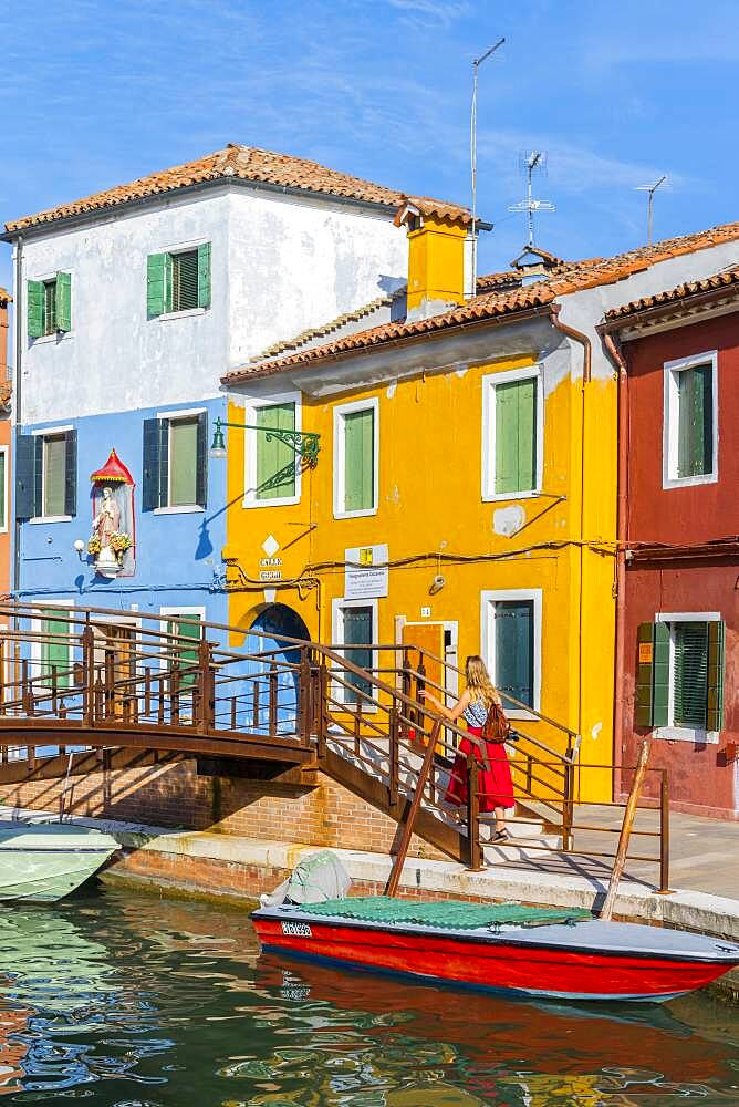 Young woman in front of colorful houses, colorful house facades, Burano Island, Venice, Veneto, Italy, Europe