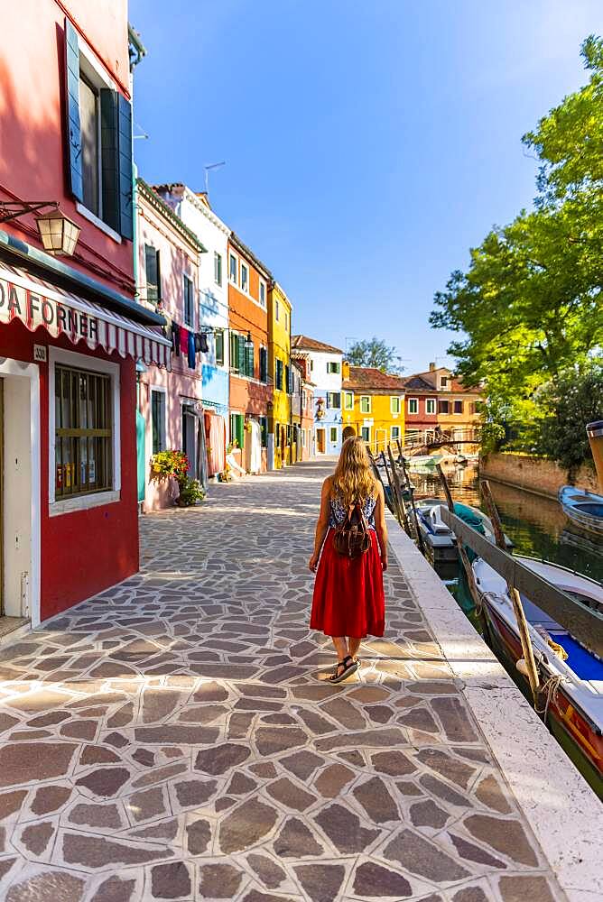 Young woman in front of colorful houses, colorful house facades, Burano Island, Venice, Veneto, Italy, Europe